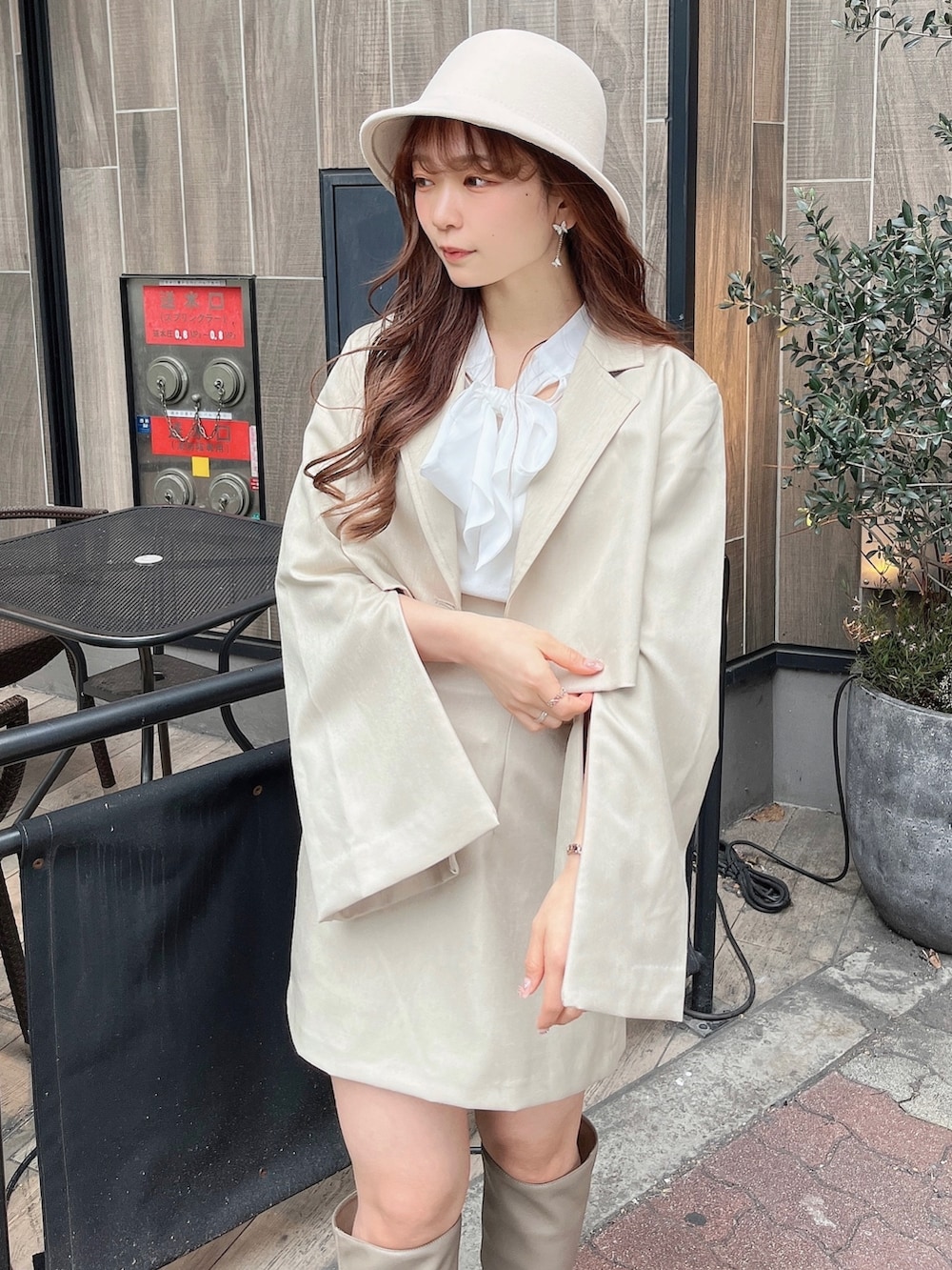 ベージュ系のテーラードジャケット、ホワイト系のニット/セーター、ベージュ系のスカートを着用したレディースの冬コーディネートの6枚目の写真