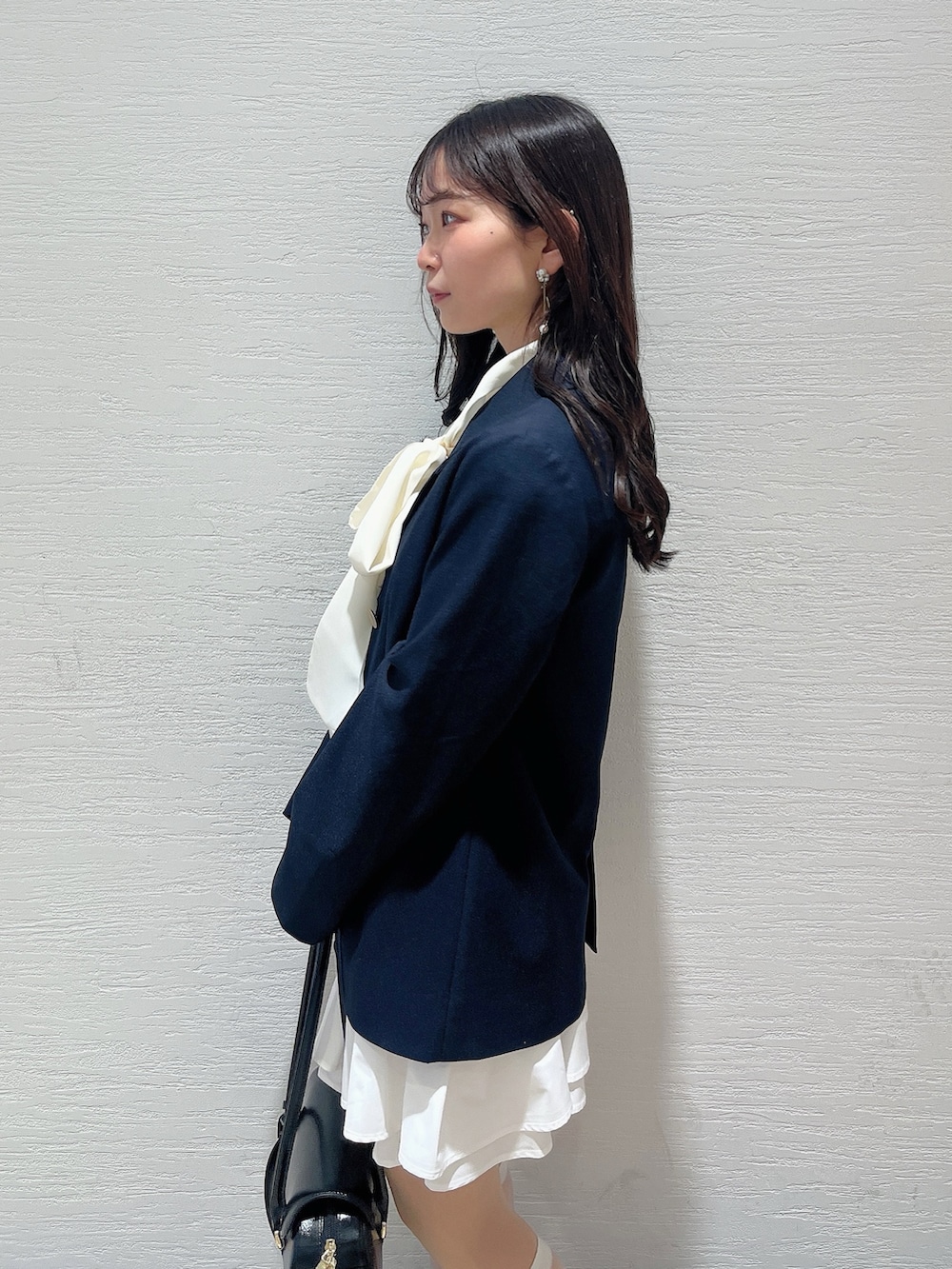 ホワイト系のシャツ/ブラウス、ホワイト系のスカート、ブラック系のバレエシューズを着用したレディースの春コーディネートの7枚目の写真