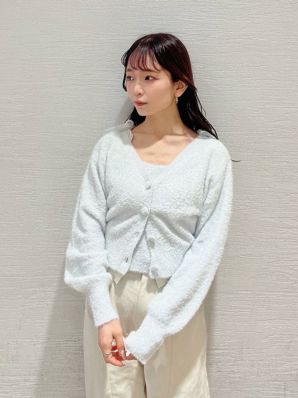 グレー系のキャミソール、グレー系のカーディガン/ボレロ、ホワイト系のデニムパンツを着用したレディースの冬コーディネートの10枚目の写真