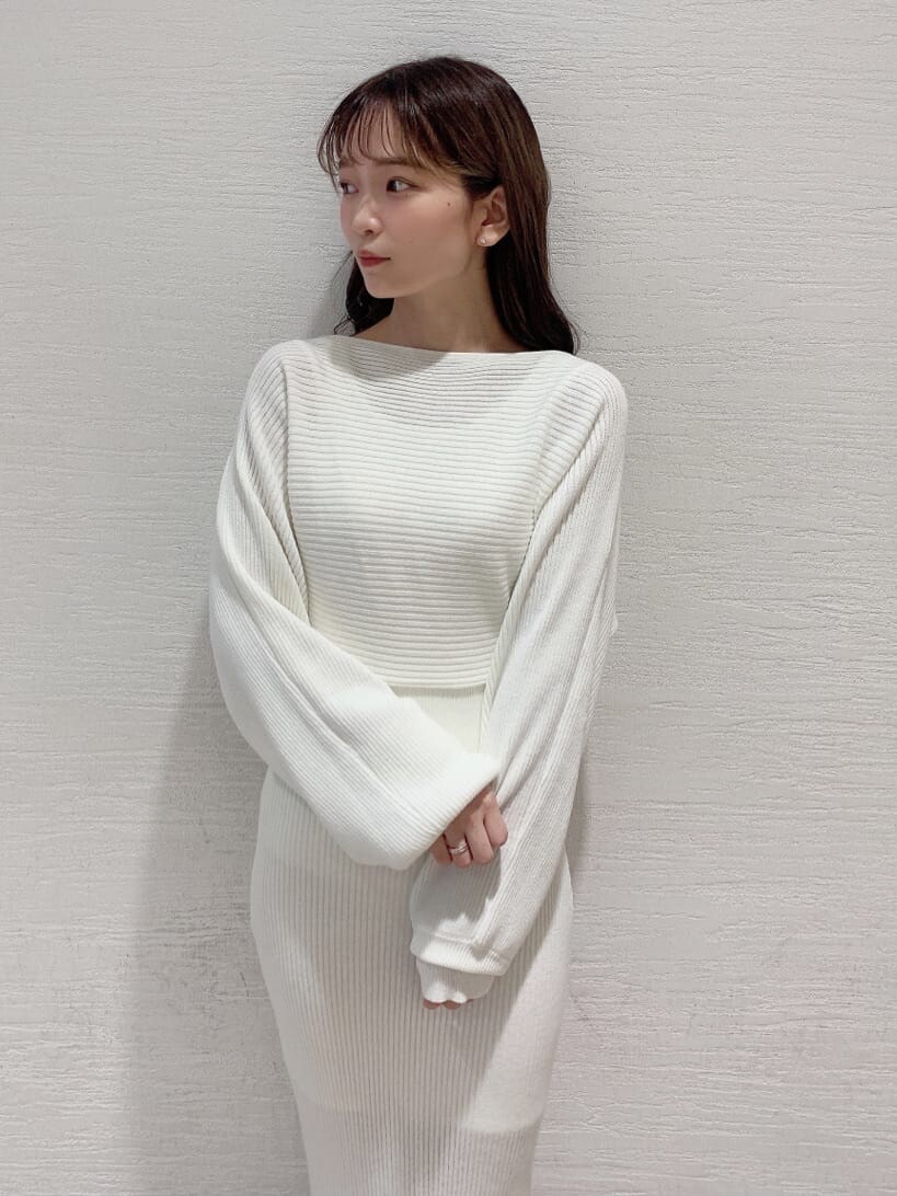 グレー系のブルゾン、ベージュ系のブーツ、ホワイト系のワンピースを着用したレディースの秋コーディネートの2枚目の写真