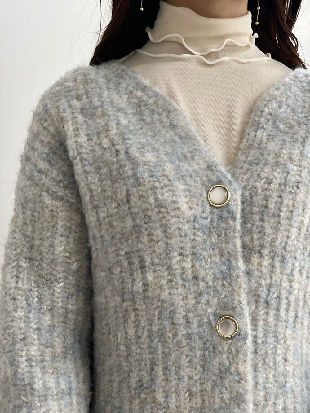 ホワイト系のTシャツ/カットソー、ブルー系のカーディガン/ボレロ、ベージュ系のブーツを着用したレディースの秋コーディネートの9枚目の写真