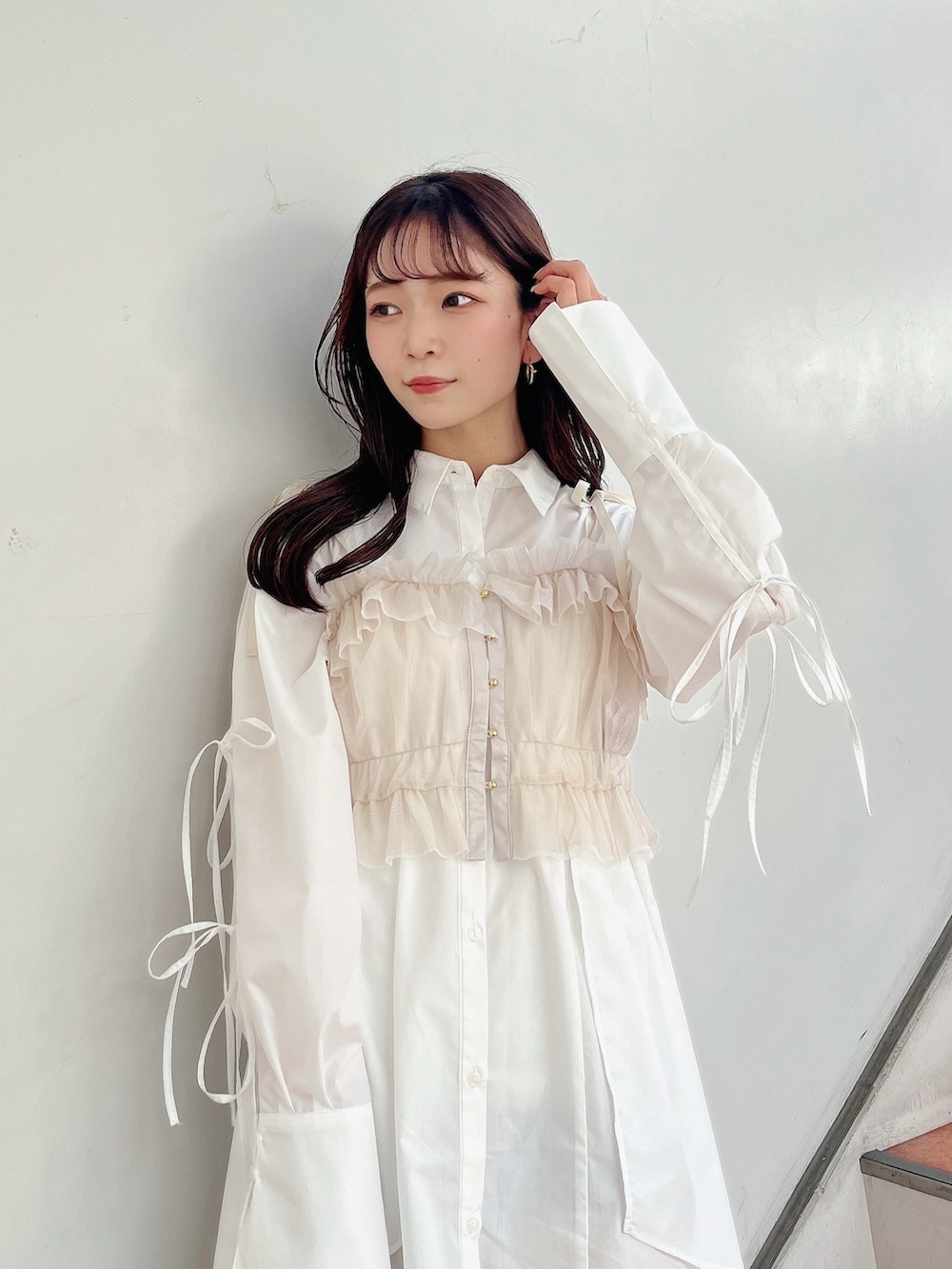 ベージュ系のキャミソール、ホワイト系のシャツワンピース、ホワイト系のブーツを着用したレディースの冬コーディネートの7枚目の写真