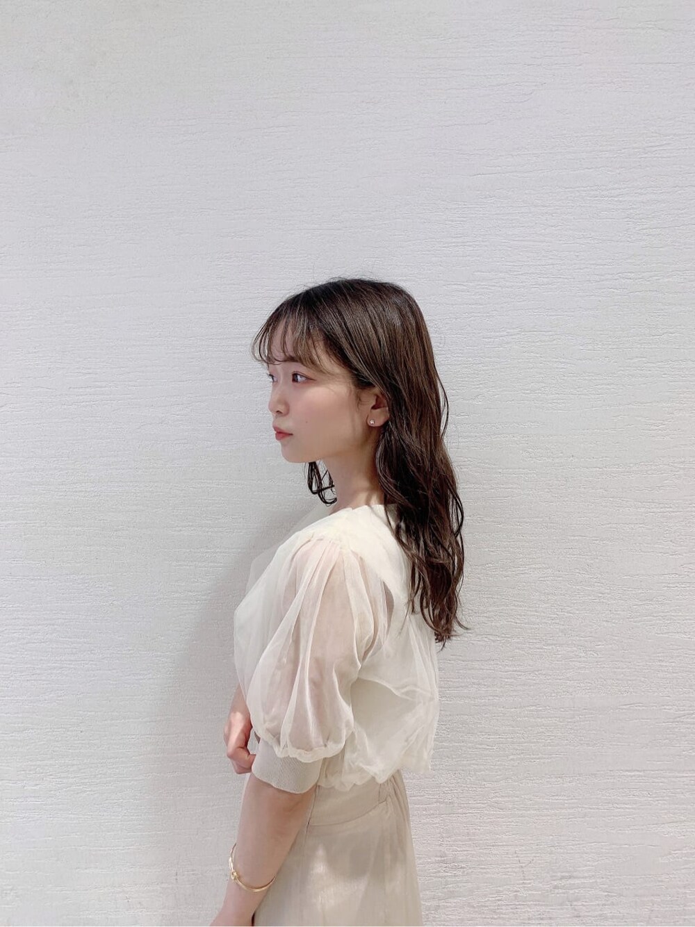 ホワイト系のスカート、ホワイト系のニット/セーター、オレンジ系のサンダルを着用したレディースの夏コーディネートの7枚目の写真