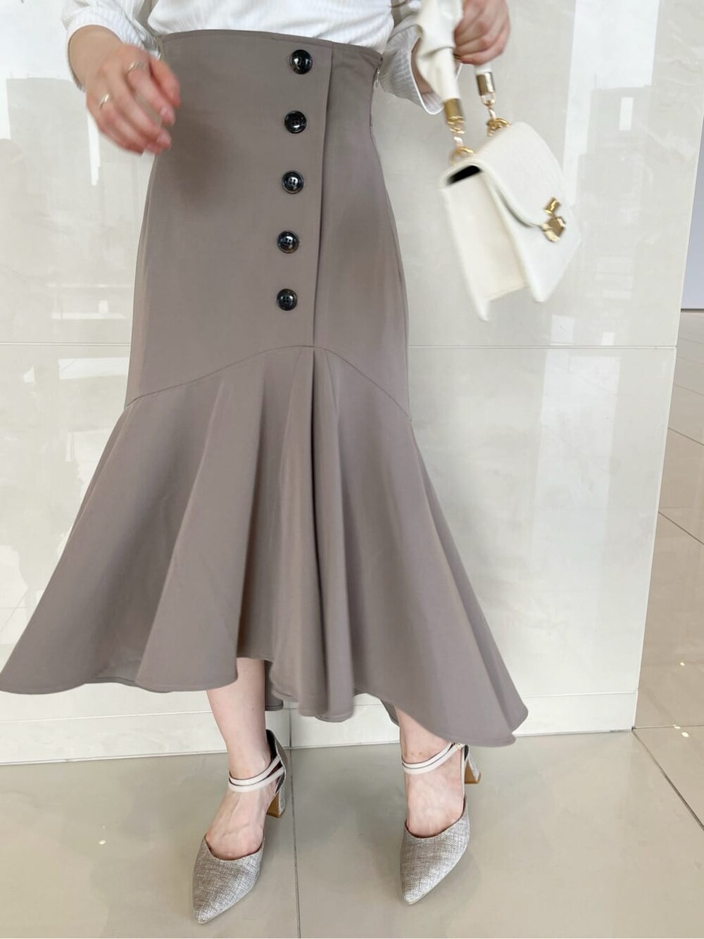 ベージュ系のスカート、ホワイト系のTシャツ/カットソーを着用したレディースの夏コーディネートの7枚目の写真