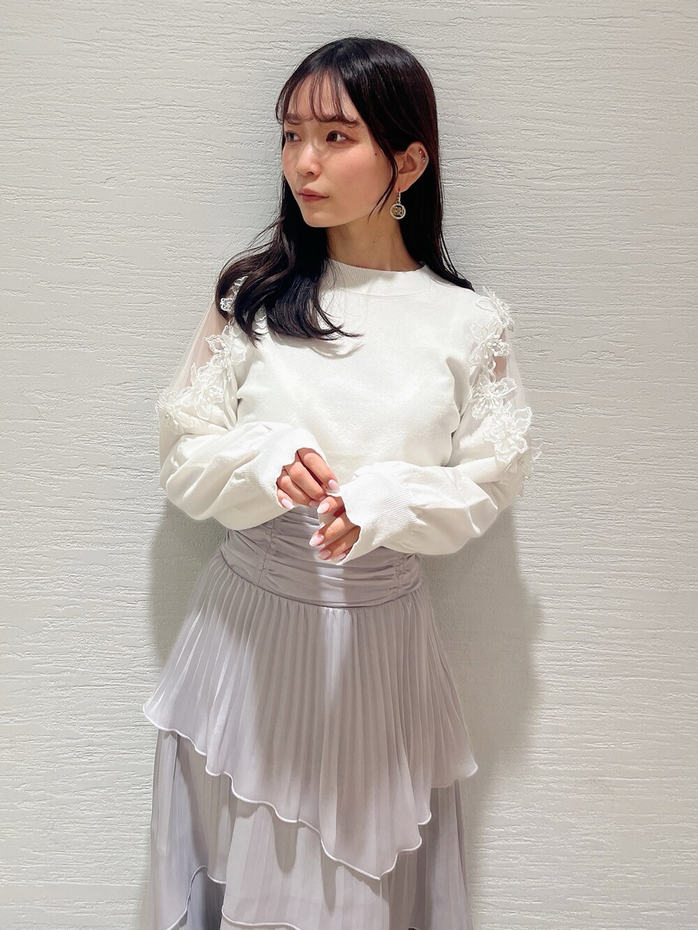 ベージュ系のブーツ、グレー系のスカート、ホワイト系のニット/セーターを着用したレディースの冬コーディネートの5枚目の写真