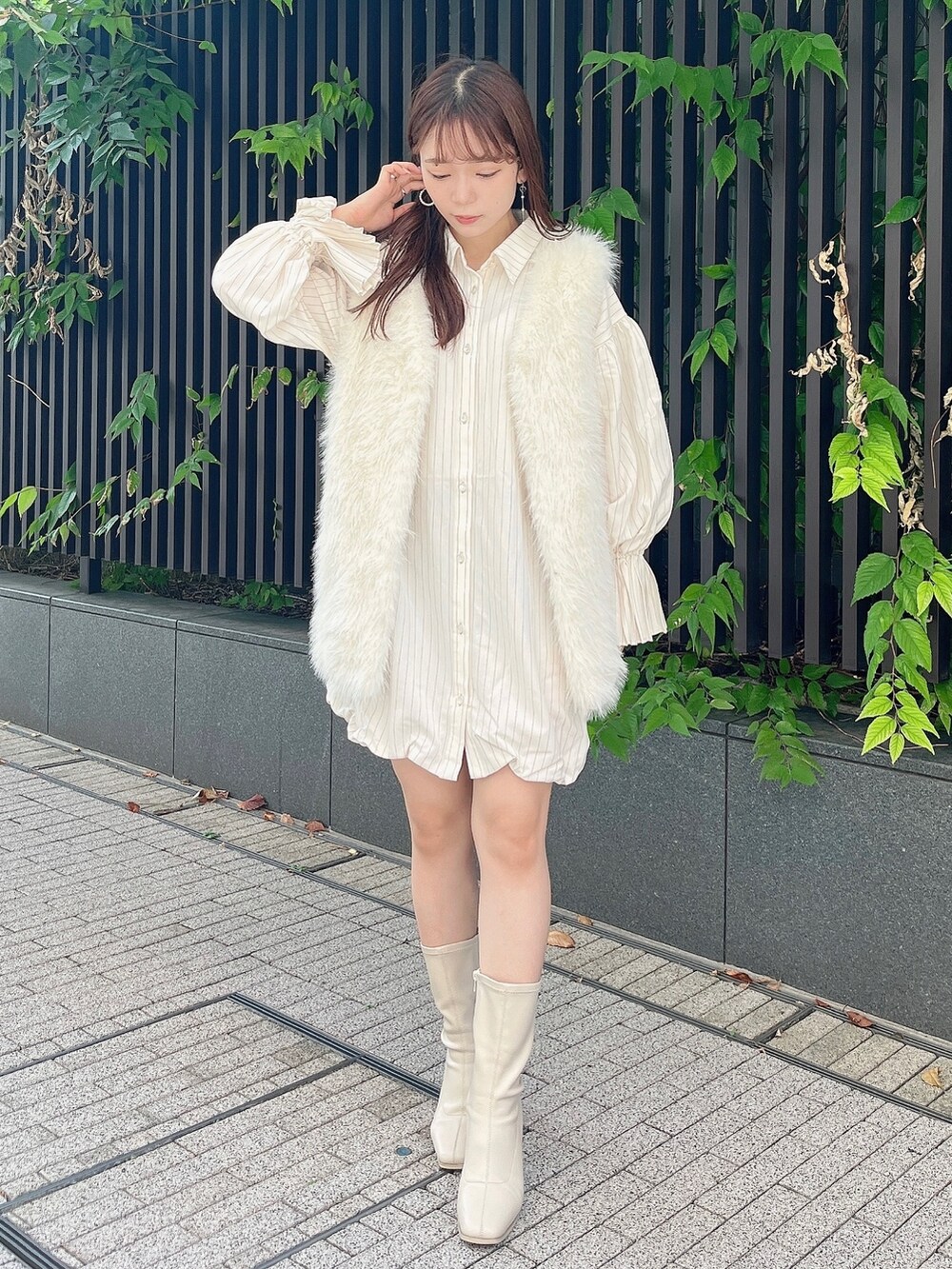 ホワイト系のベスト、ベージュ系のワンピース、ホワイト系のブーツを着用したレディースの秋コーディネートの5枚目の写真