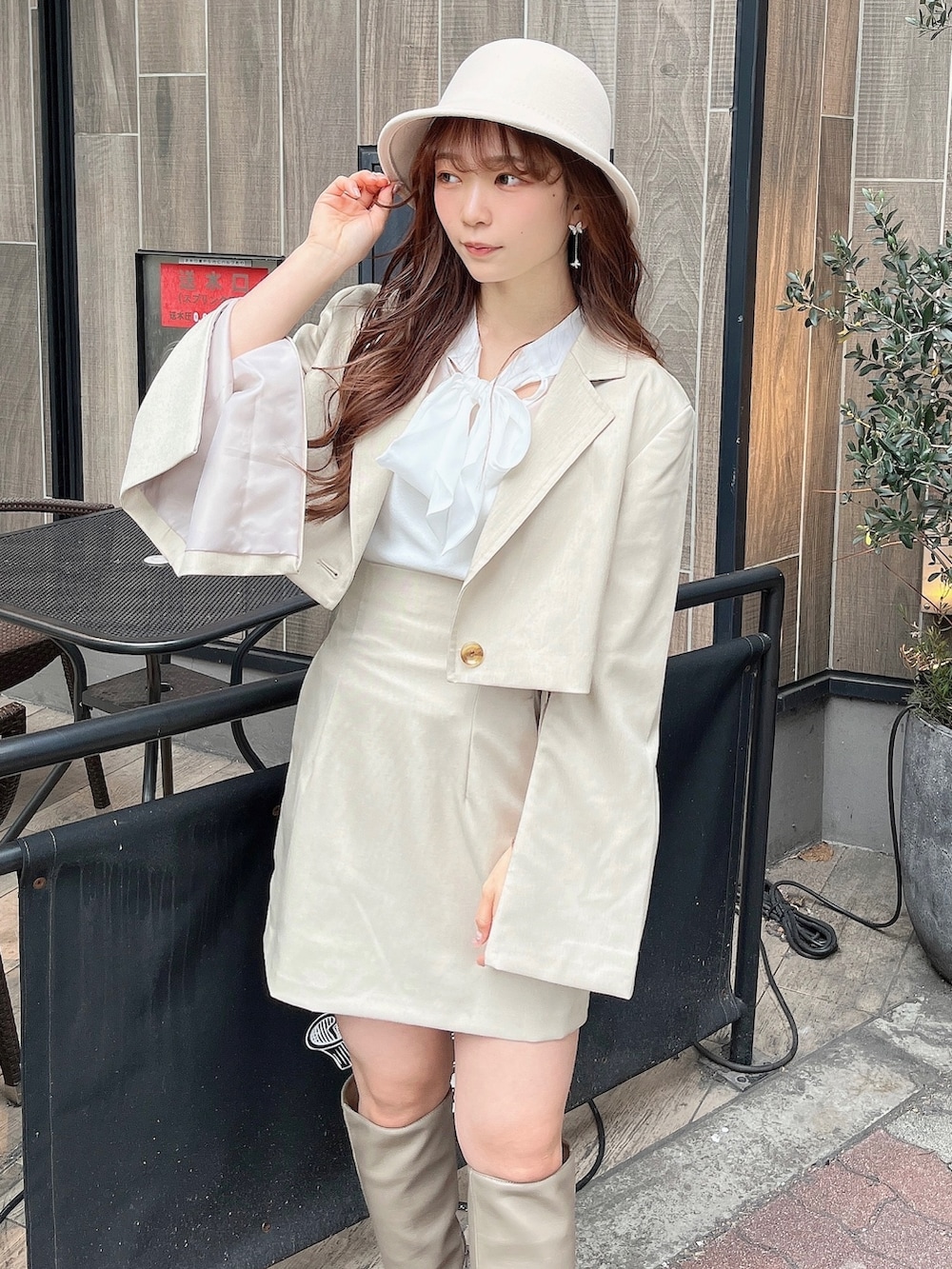 ベージュ系のテーラードジャケット、ホワイト系のニット/セーター、ベージュ系のスカートを着用したレディースの冬コーディネートの8枚目の写真