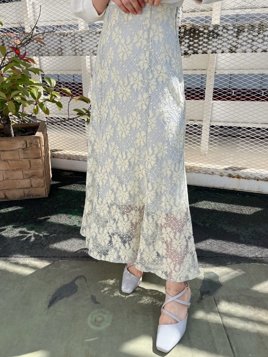 ブルー系のスカート、ホワイト系のニット/セーター、グレー系のパンプスを着用したレディースの春コーディネートの8枚目の写真