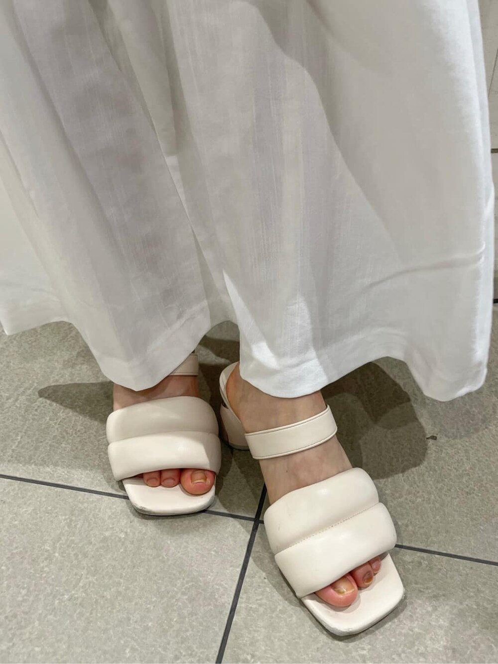 ホワイト系のワンピース、ホワイト系のサンダル、ベージュ系のハットを着用したレディースの夏コーディネートの10枚目の写真