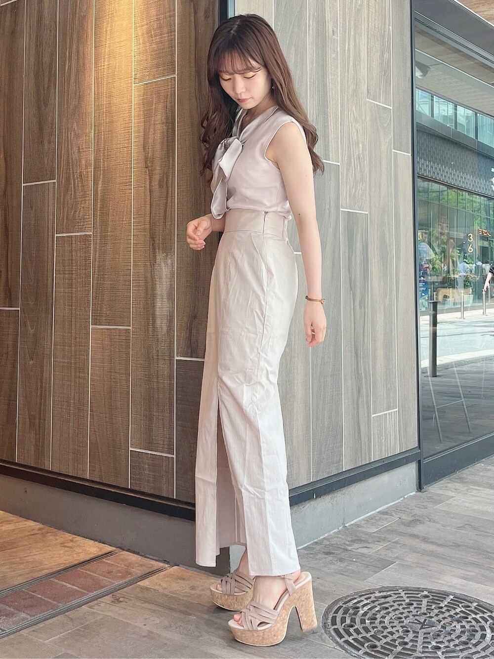 ベージュ系のサンダル、グレー系のニット/セーター、ベージュ系のスカートを着用したレディースの夏コーディネートの2枚目の写真