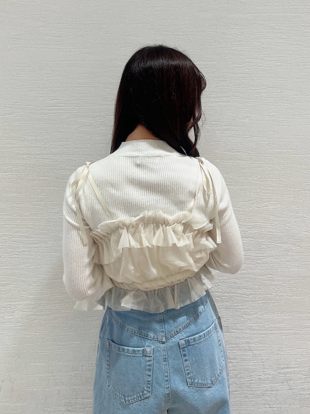 ベージュ系のブーツ、ブルー系のデニムパンツ、ベージュ系のキャミソールを着用したレディースの冬コーディネートの9枚目の写真