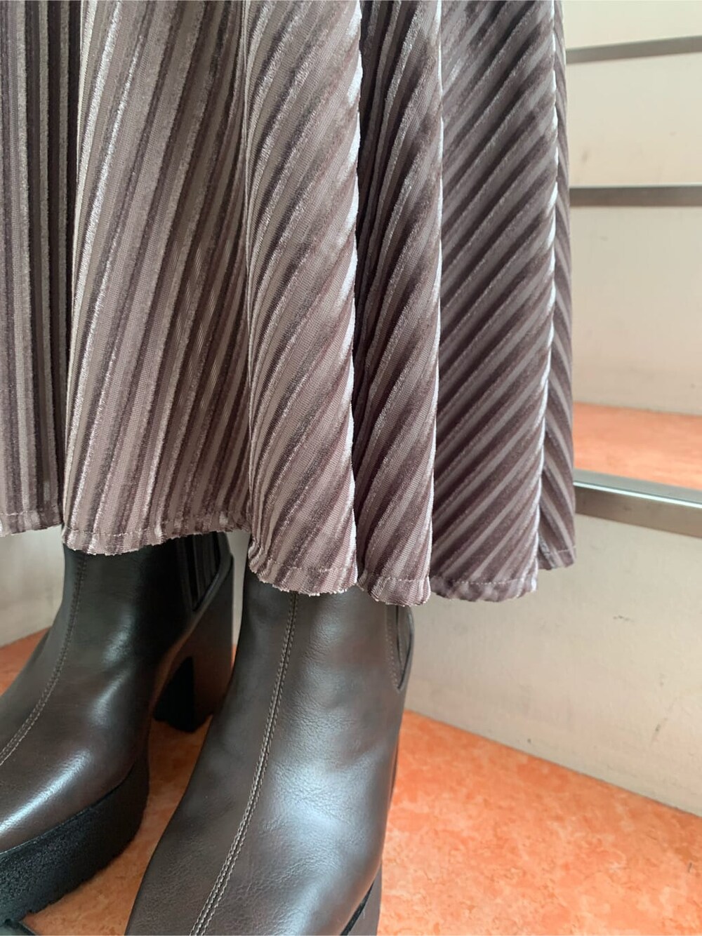 ホワイト系のニット/セーター、ブラウン系のブーツ、ベージュ系のスカートを着用したレディースの秋コーディネートの10枚目の写真