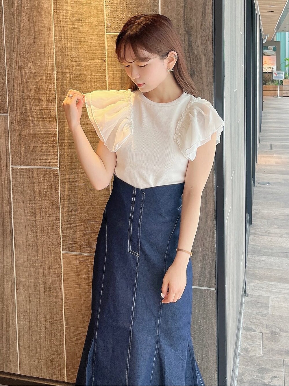 ブルー系のスカート、ホワイト系のTシャツ/カットソー、ホワイト系のパンプスを着用したレディースの夏コーディネートの4枚目の写真