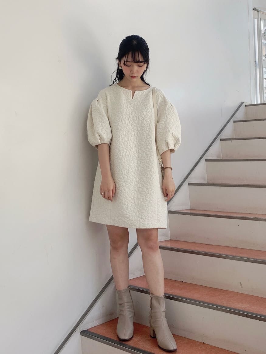 ホワイト系のチュニック、ベージュ系のショルダーバッグ、ベージュ系のブーツを着用したレディースの秋コーディネートの2枚目の写真