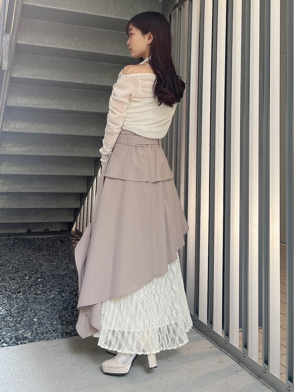 ベージュ系のハンドバッグ、ベージュ系のブーツ、ホワイト系のTシャツ/カットソーを着用したレディースの春コーディネートの3枚目の写真