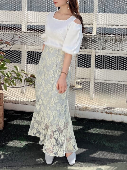 ブルー系のスカート、ホワイト系のニット/セーター、グレー系のパンプスを着用したレディースの春コーディネートの3枚目の写真