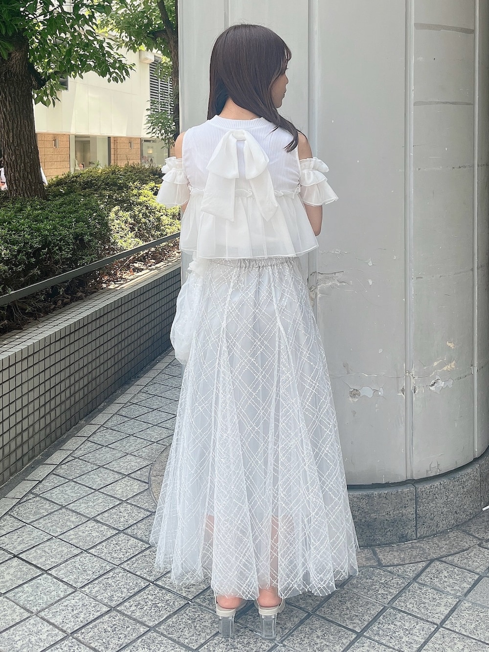 ホワイト系のTシャツ/カットソー、ホワイト系のパンプス、グレー系のスカートを着用したレディースの夏コーディネートの3枚目の写真