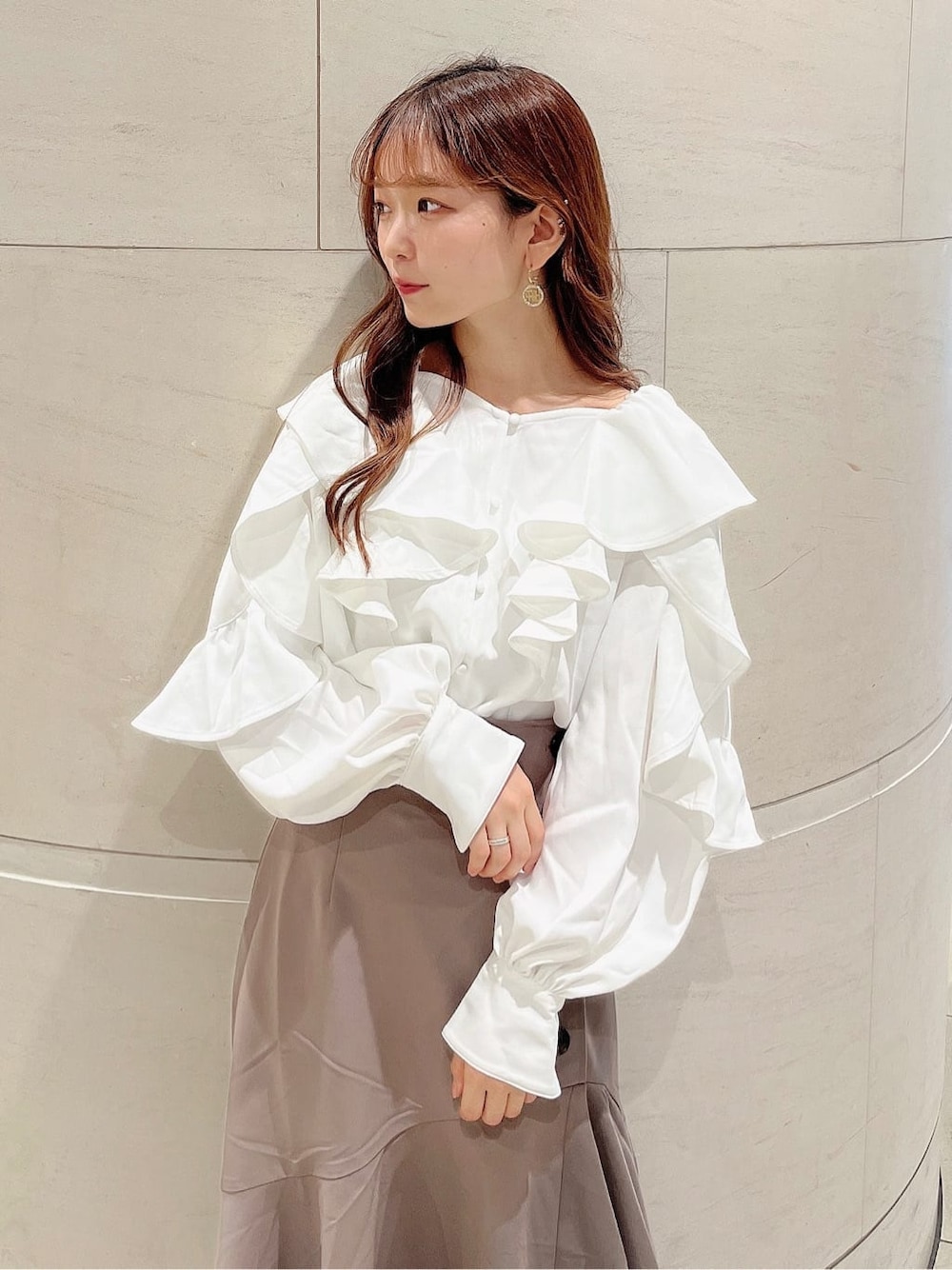 ベージュ系のブーツ、ベージュ系のスカート、ホワイト系のシャツ/ブラウスを着用したレディースの秋コーディネートの5枚目の写真