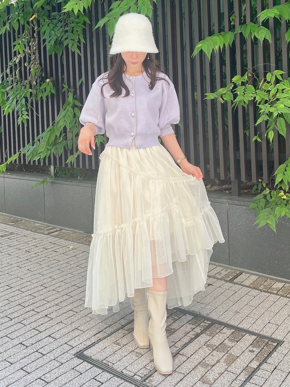 パープル系のカーディガン/ボレロ、ホワイト系のスカート、ホワイト系のブーツを着用したレディースの夏コーディネートの5枚目の写真