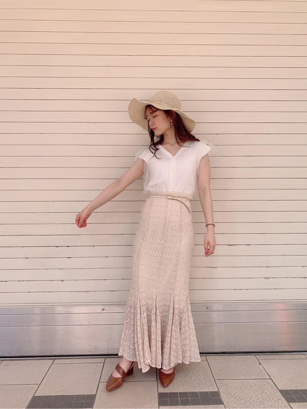 ホワイト系のスカート、ブラウン系のパンプス、ホワイト系のニット/セーターを着用したレディースの春コーディネートの3枚目の写真