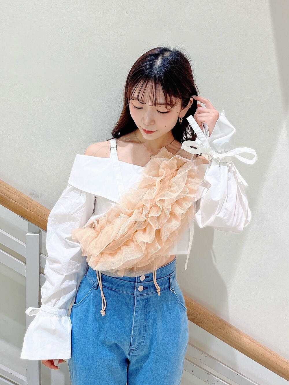 オレンジ系のベスト、ブルー系のデニムパンツ、ホワイト系のシャツ/ブラウスを着用したレディースの春コーディネートの10枚目の写真