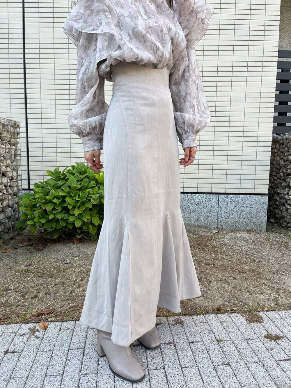 ベージュ系のスカート、ベージュ系のブーツ、ベージュ系のシャツ/ブラウスを着用したレディースの秋コーディネートの8枚目の写真