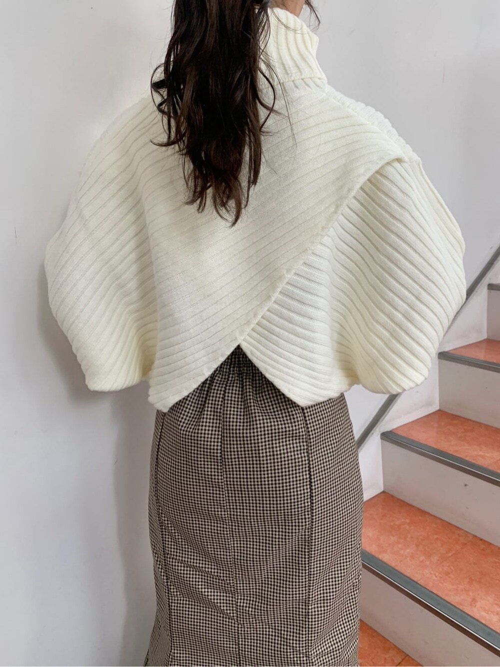 ブラウン系のブーツ、ブラウン系のスカート、ホワイト系のニット/セーターを着用したレディースの秋コーディネートの10枚目の写真