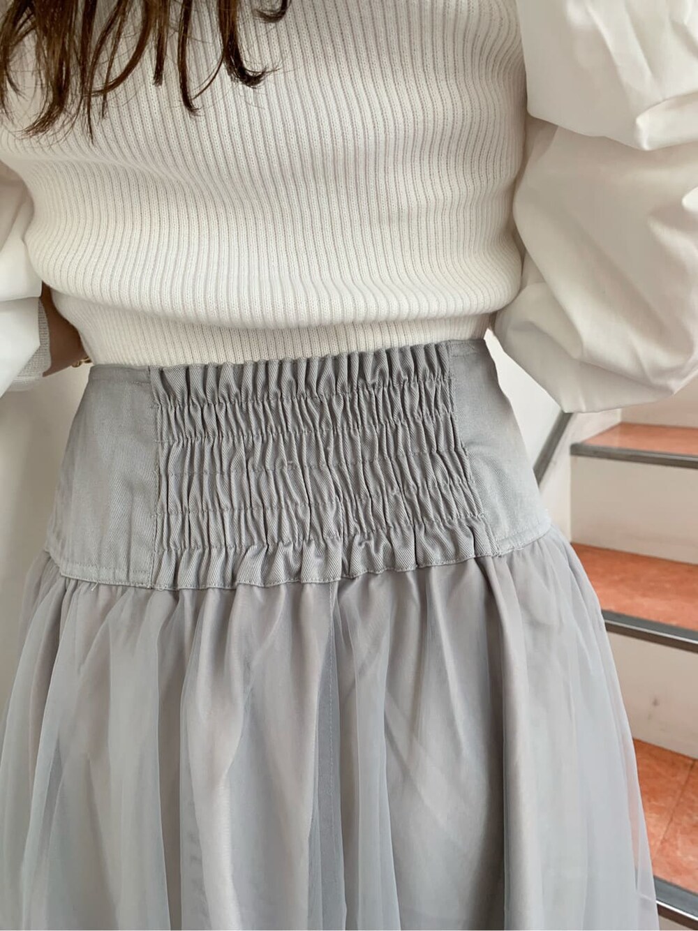 グレー系のスカート、ホワイト系のパンプス、ホワイト系のニット/セーターを着用したレディースの秋コーディネートの10枚目の写真