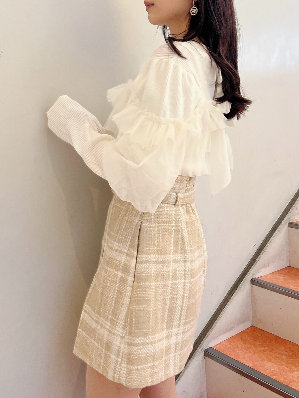 ホワイト系のニット/セーター、ベージュ系のスカート、ベージュ系のブーツを着用したレディースの冬コーディネートの7枚目の写真