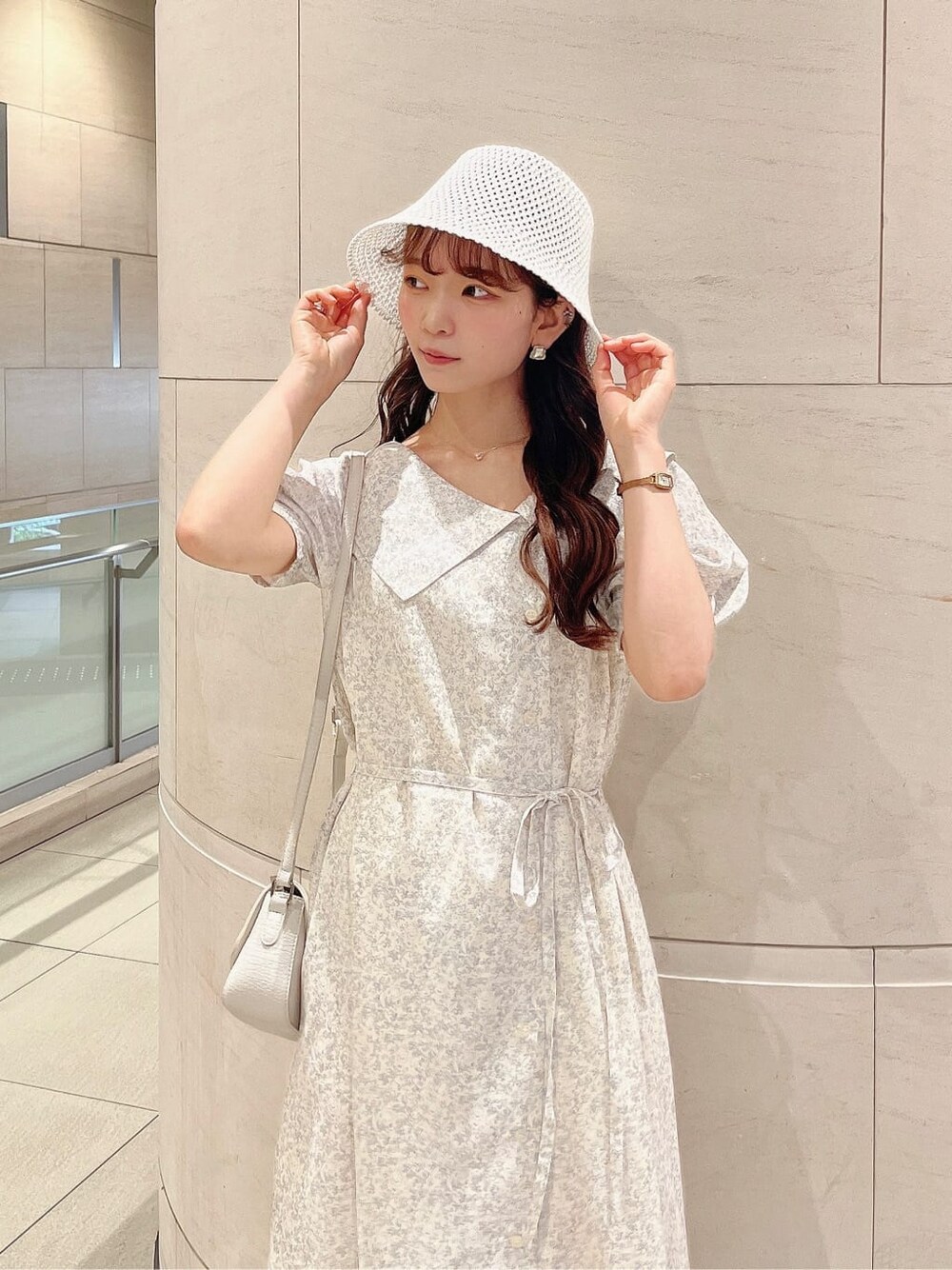 ベージュ系のサンダル、ホワイト系のワンピース、ホワイト系のハットを着用したレディースの春コーディネートの4枚目の写真