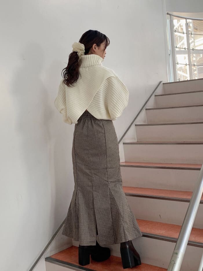 ブラウン系のブーツ、ブラウン系のスカート、ホワイト系のニット/セーターを着用したレディースの秋コーディネートの4枚目の写真