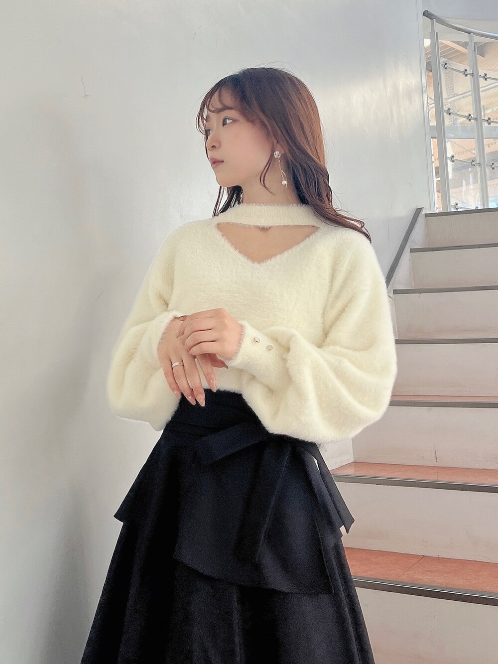 ホワイト系のブーツ、ブラック系のスカート、ホワイト系のニット/セーターを着用したレディースの秋コーディネートの7枚目の写真