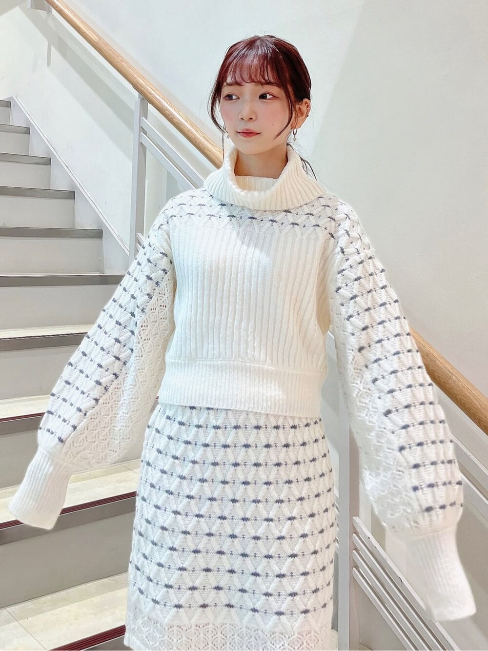 ベージュ系のブーツ、ホワイト系のニット/セーター、ホワイト系のスカートを着用したレディースの秋コーディネートの6枚目の写真