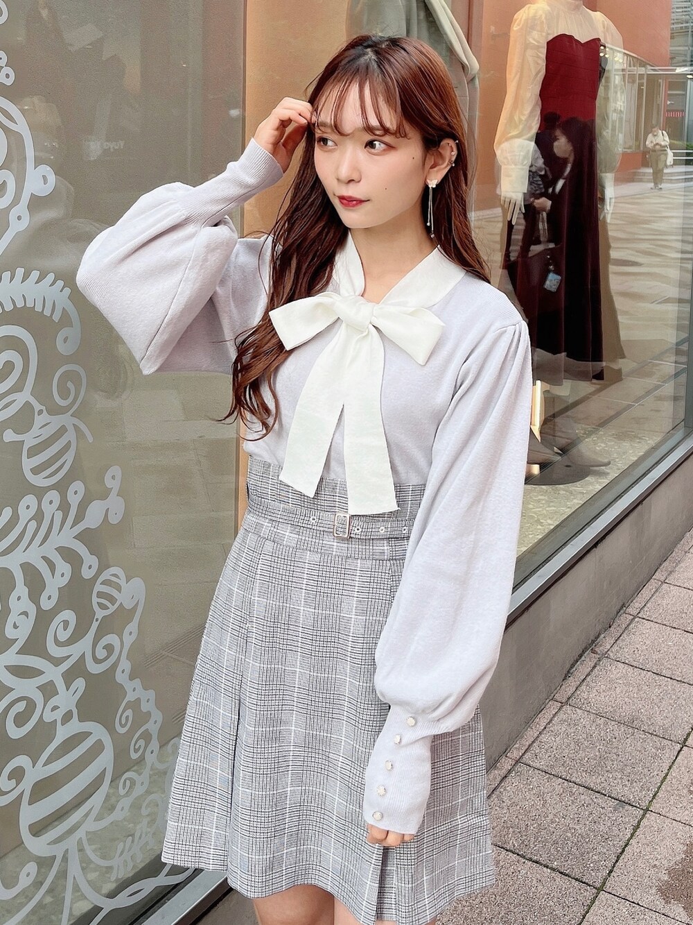 グレー系のニット/セーター、グレー系のスカート、ベージュ系のブーツを着用したレディースの冬コーディネートの8枚目の写真