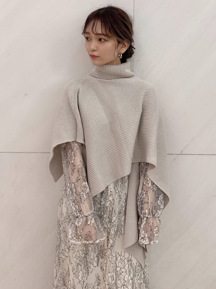 ホワイト系のワンピース、ベージュ系のニット/セーター、ホワイト系のパンプスを着用したレディースの秋コーディネートの2枚目の写真