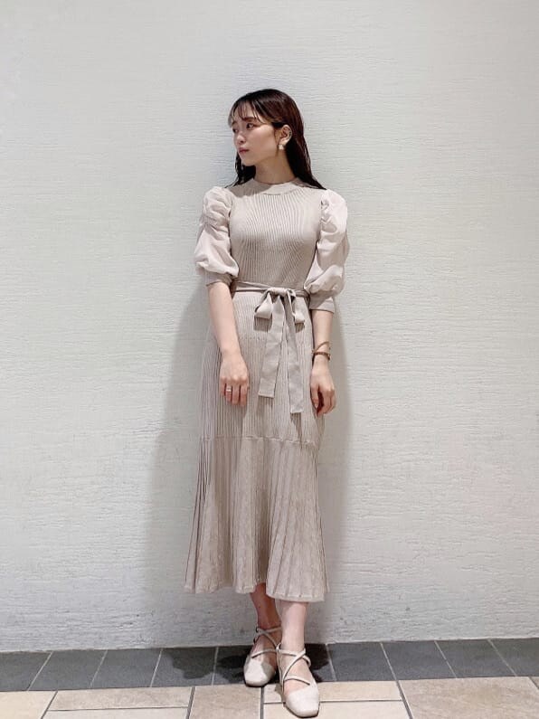 ホワイト系のパンプス、ベージュ系のワンピースを着用したレディースの夏コーディネートの2枚目の写真