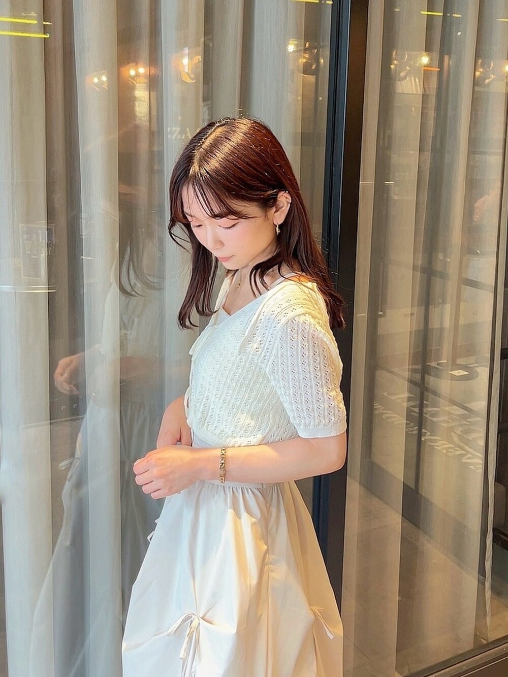 ホワイト系のニット/セーター、ホワイト系のスカートを着用したレディースの夏コーディネートの8枚目の写真