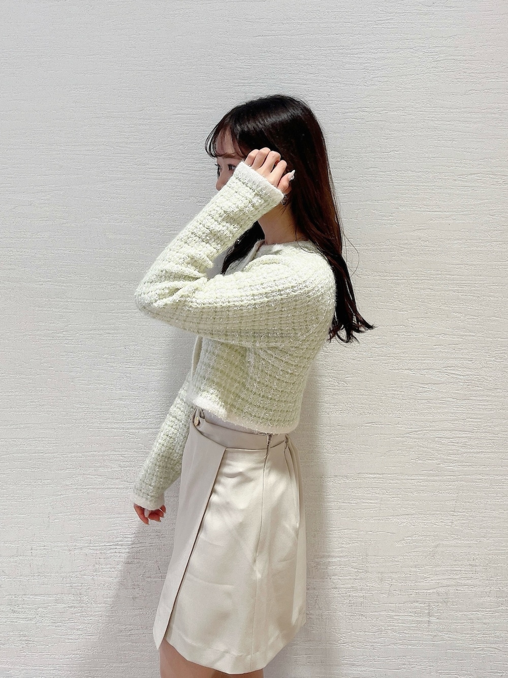 グリーン系のノーカラージャケット、ホワイト系のブーツ、ホワイト系のスカートを着用したレディースの冬コーディネートの9枚目の写真