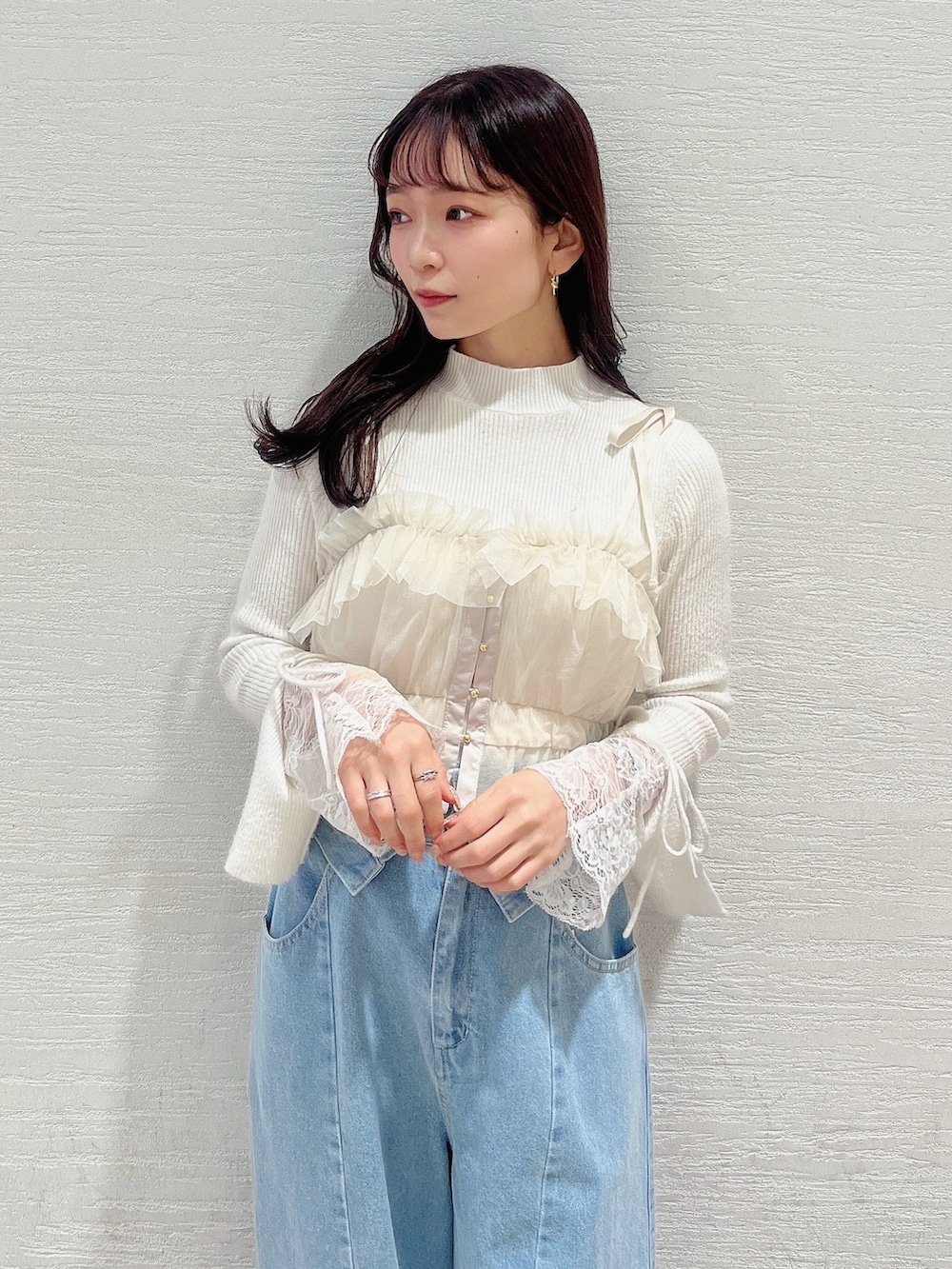 ベージュ系のブーツ、ブルー系のデニムパンツ、ベージュ系のキャミソールを着用したレディースの冬コーディネートの7枚目の写真