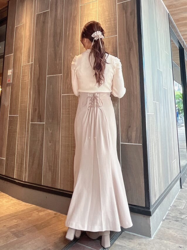 ベージュ系のブーツ、ベージュ系のスカート、ホワイト系のニット/セーターを着用したレディースの秋コーディネートの4枚目の写真