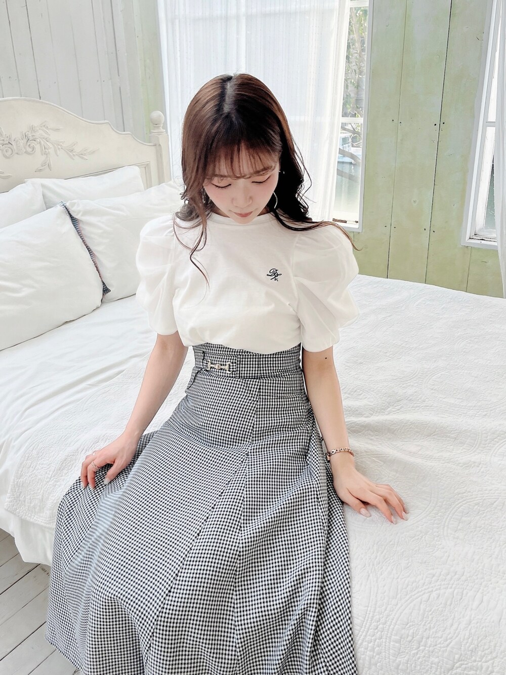 ホワイト系のTシャツ/カットソー、ブラック系のスカート、ブラック系のパンプスを着用したレディースの春コーディネートの5枚目の写真