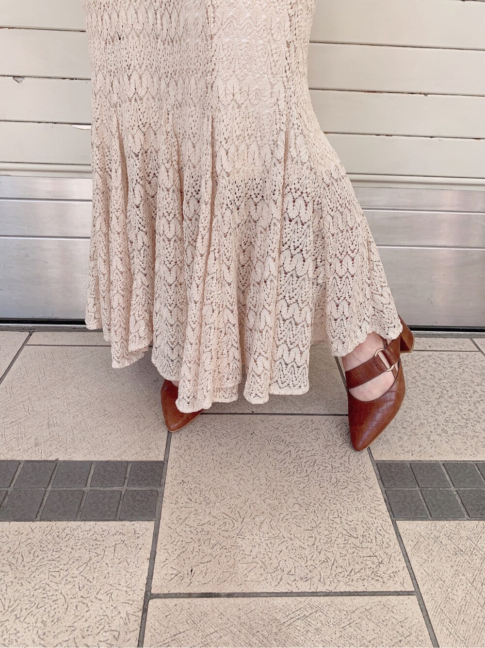 ホワイト系のスカート、ブラウン系のパンプス、ホワイト系のニット/セーターを着用したレディースの春コーディネートの10枚目の写真