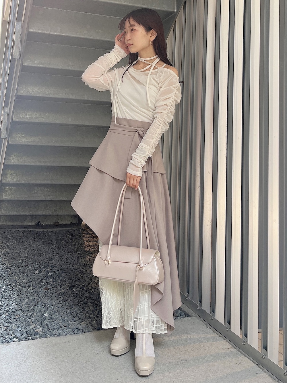 ベージュ系のハンドバッグ、ベージュ系のブーツ、ホワイト系のTシャツ/カットソーを着用したレディースの春コーディネートの2枚目の写真