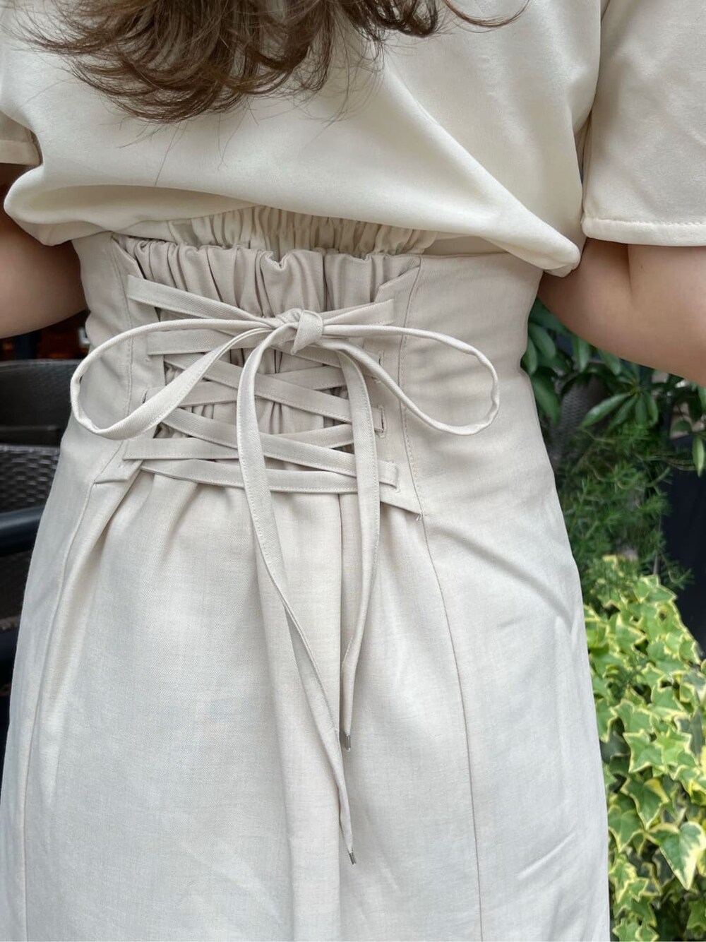 ベージュ系のサンダル、ホワイト系のスカート、ホワイト系のTシャツ/カットソーを着用したレディースの春コーディネートの9枚目の写真