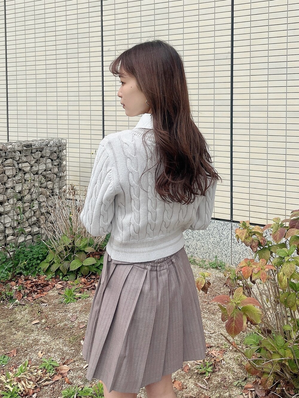 ベージュ系のブーツ、ベージュ系のスカート、グレー系のニット/セーターを着用したレディースの冬コーディネートの10枚目の写真