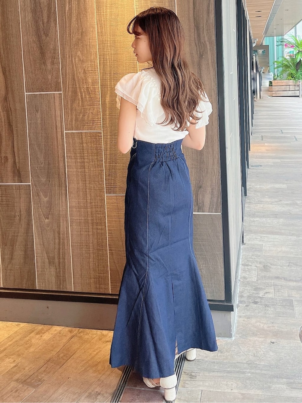 ブルー系のスカート、ホワイト系のTシャツ/カットソー、ホワイト系のパンプスを着用したレディースの夏コーディネートの3枚目の写真