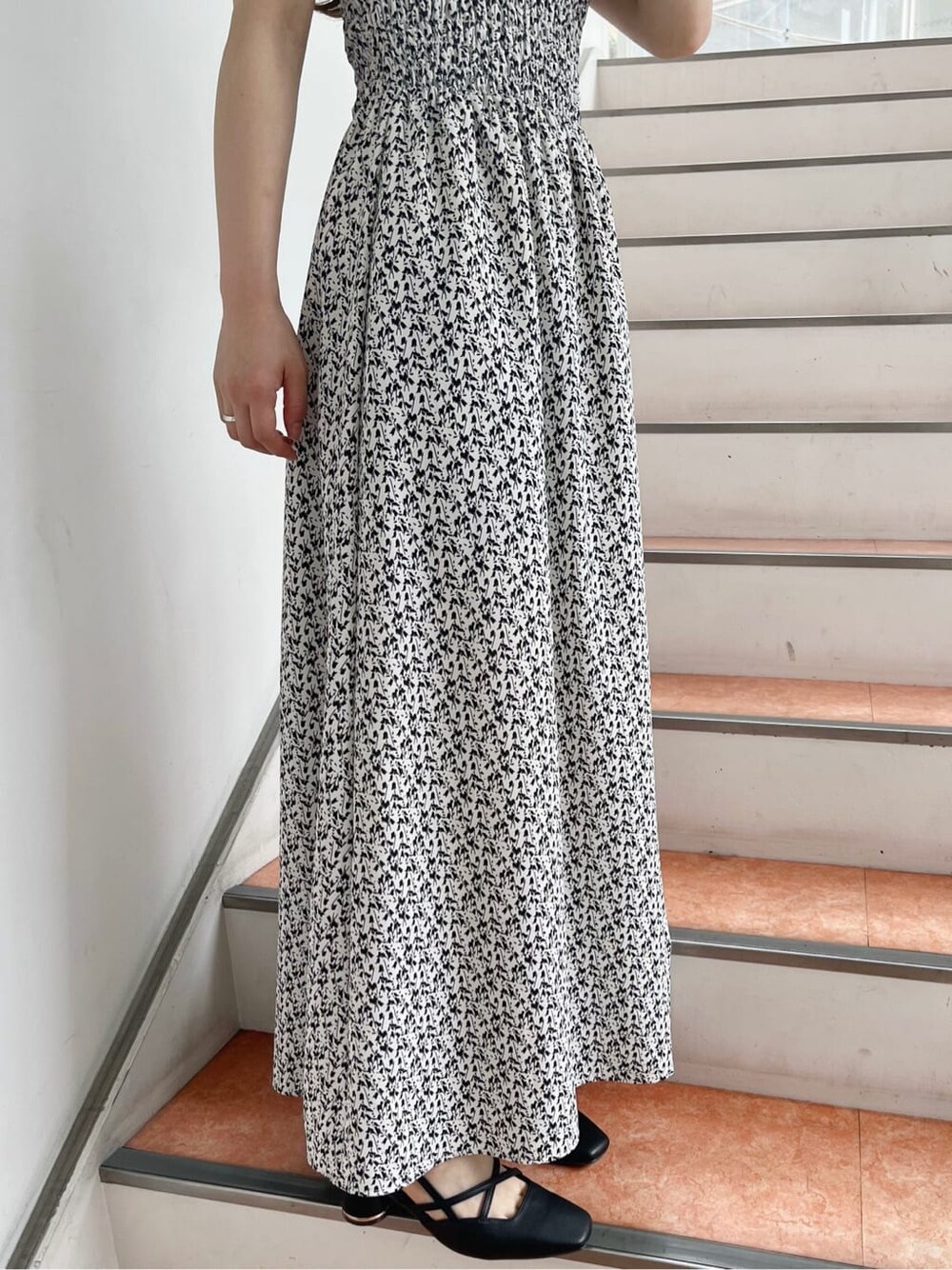 ホワイト系のワンピース、ブラック系のパンプスを着用したレディースの夏コーディネートの8枚目の写真