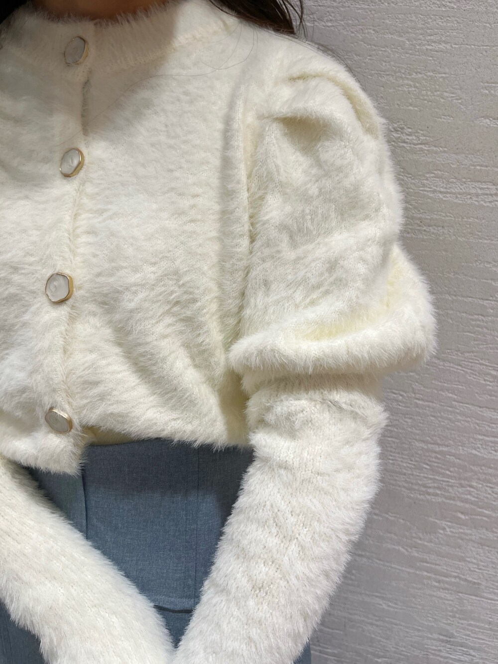 ホワイト系のニット/セーター、ブルー系のスカート、ベージュ系のブーツを着用したレディースの冬コーディネートの8枚目の写真