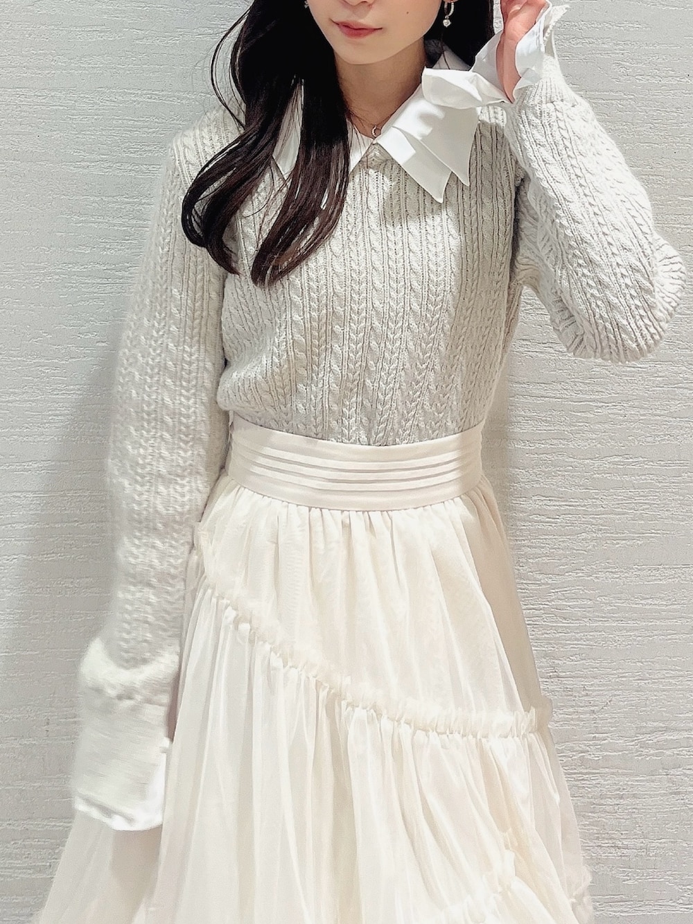 ベージュ系のニット/セーター、ホワイト系のスカート、ベージュ系のブーツを着用したレディースの冬コーディネートの7枚目の写真