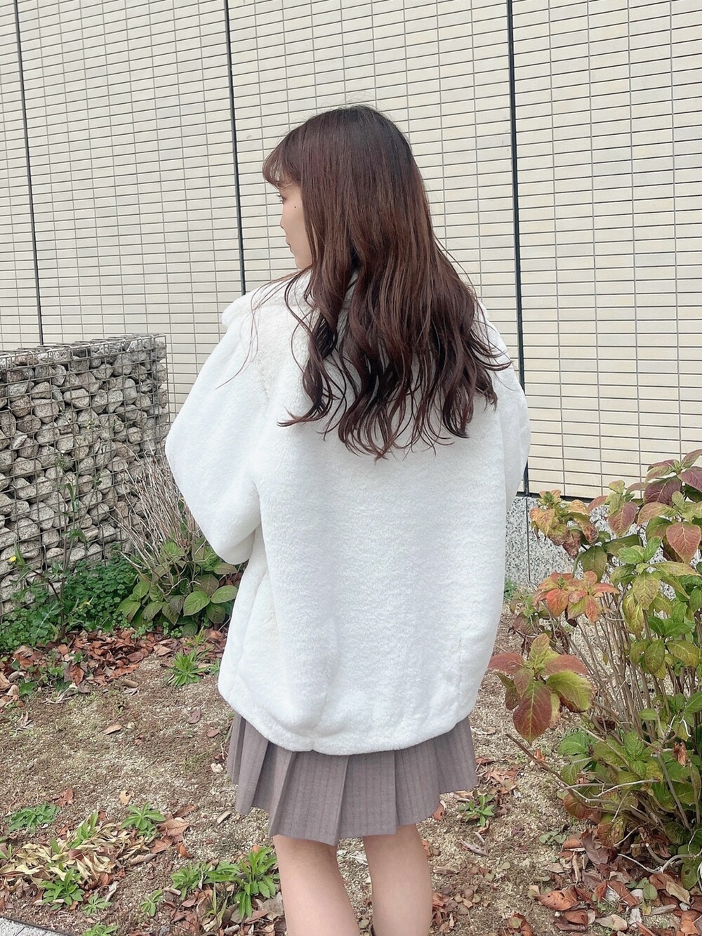 ベージュ系のブーツ、ベージュ系のスカート、グレー系のニット/セーターを着用したレディースの冬コーディネートの4枚目の写真